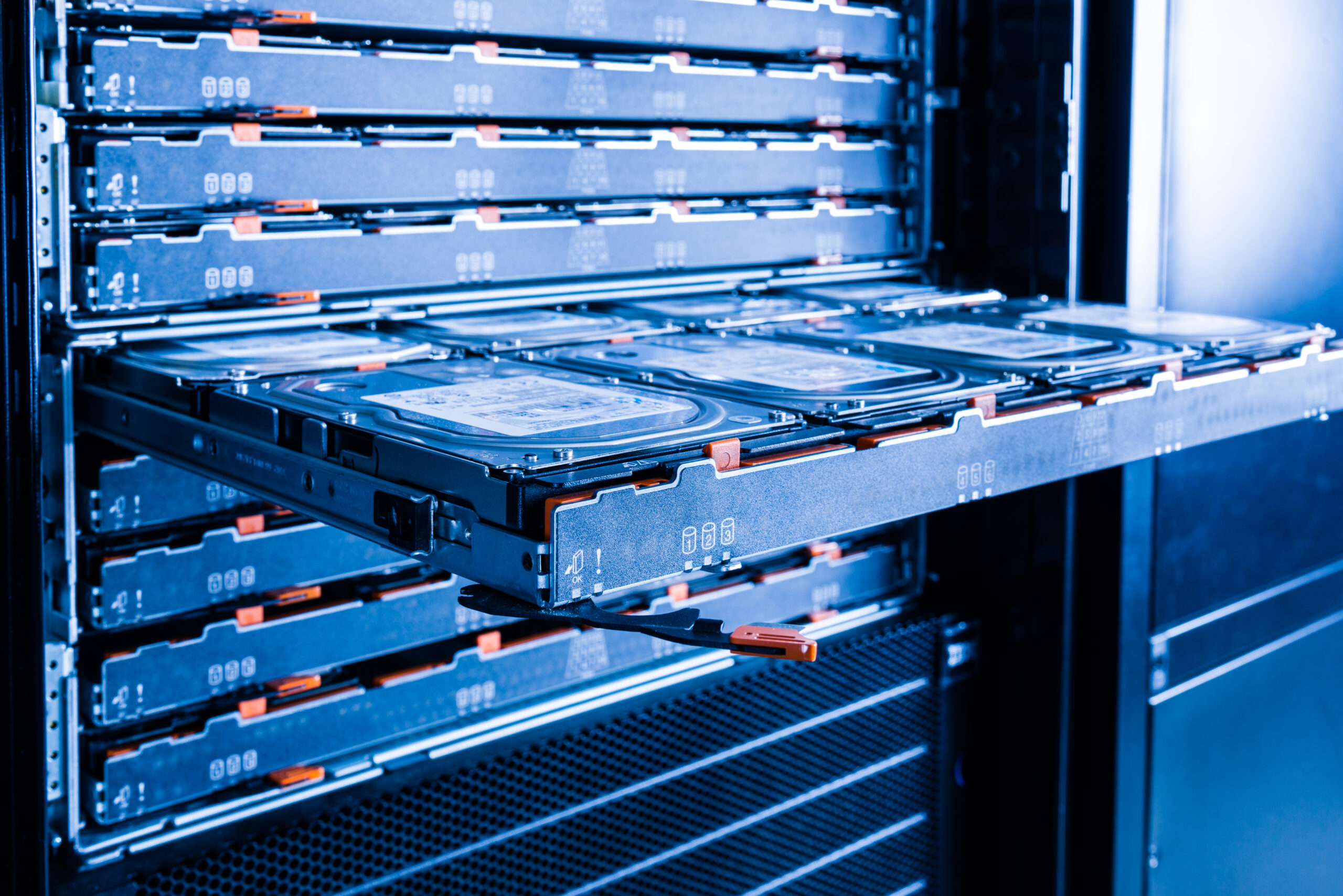 A brightly lit data center server room with rows of racks