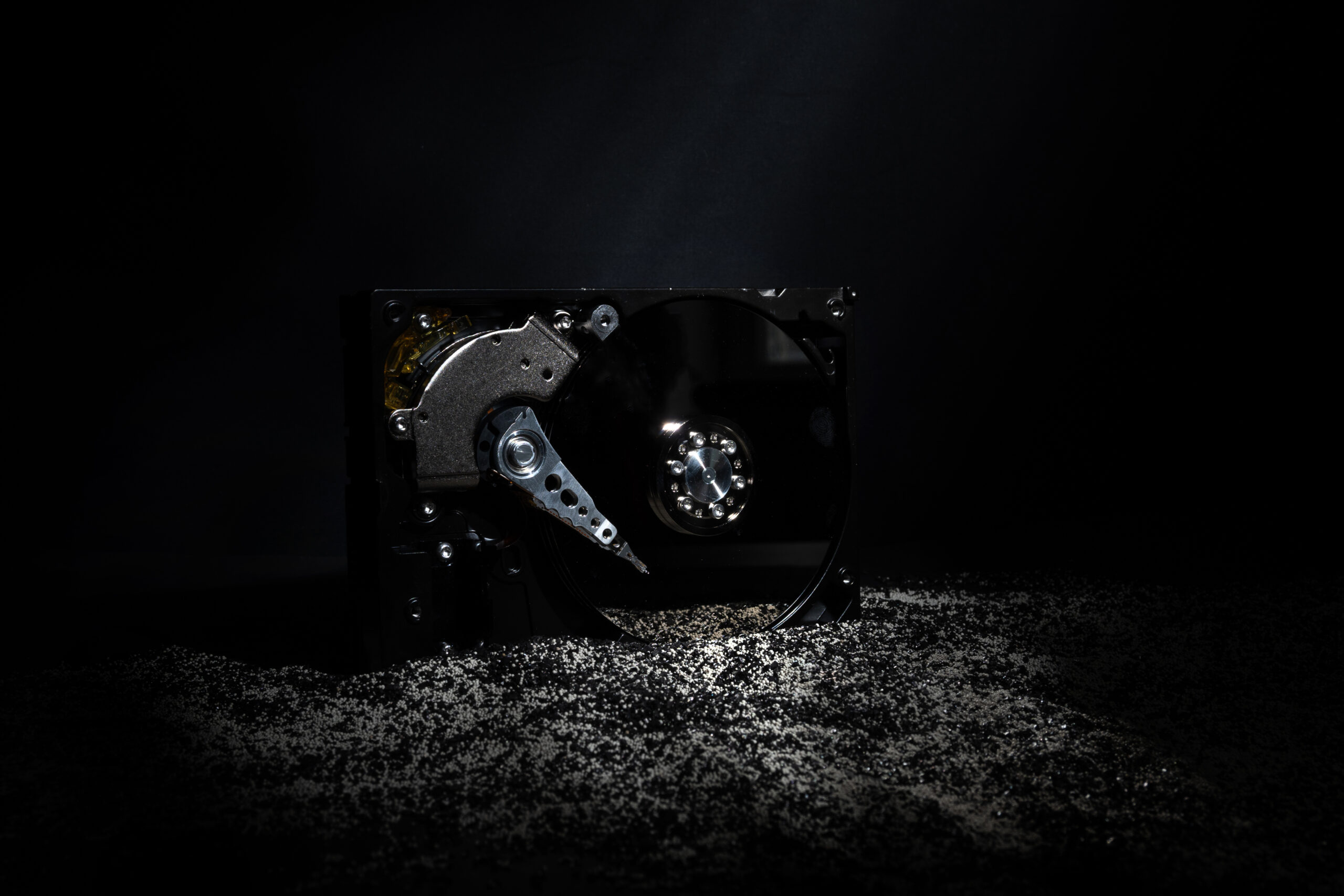 An open hard disk drive lit dramatically against a black background